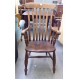 A late 19thC beech and elm framed Windsor lath back grandfather chair, the solid seat raised on ring