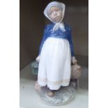 A Royal Copenhagen porcelain figure, a Dutch girl carrying a water bottle and cooking pot  No.815