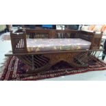 A modern Asian, mahogany, traditionally styled and carved, galleried daybed/bench seat with a floral