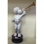 A white painted carved wooden figure, a trumpeting cherub, on a circular plinth  22"h overall