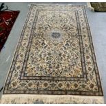 A Persian design part-silk rug, profusely decorated with floral imagery, on a cream coloured ground