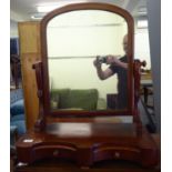 An early Victorian toilet mirror, the round arch top plate set in a mahogany frame, pivoting on a