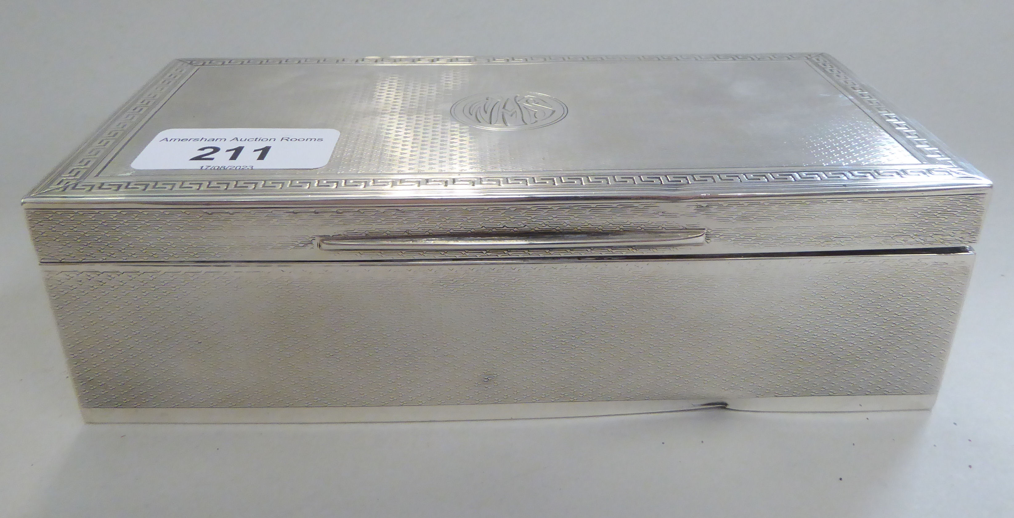 A silver cigarette box, decorated with Greek Key ornament  Sheffield 1919  2"h  7"w