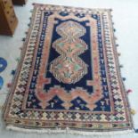 A Persian design rug, decorated with three guls and geometric patterns, on a blue ground  56" x 94"