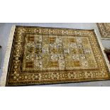 A Persian design part-silk rug, decorated with flora and geometric patterns, on a beige ground