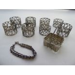 White metalware: to include a set of eight scrolled wire napkin rings