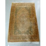 A Persian design rug with floral motifs, on a brown ground  60" x 36"