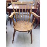 An early 20thC beech and elm framed Windsor chair with a spindled comb back and open arms, the solid