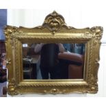 A 19thC mirror, the plate set in an elaborately scrolled gilt frame  26" x 30"