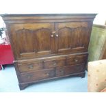 An early 19thC country made, dowelled oak cupboard, enclosed by a pair of panelled doors, over an