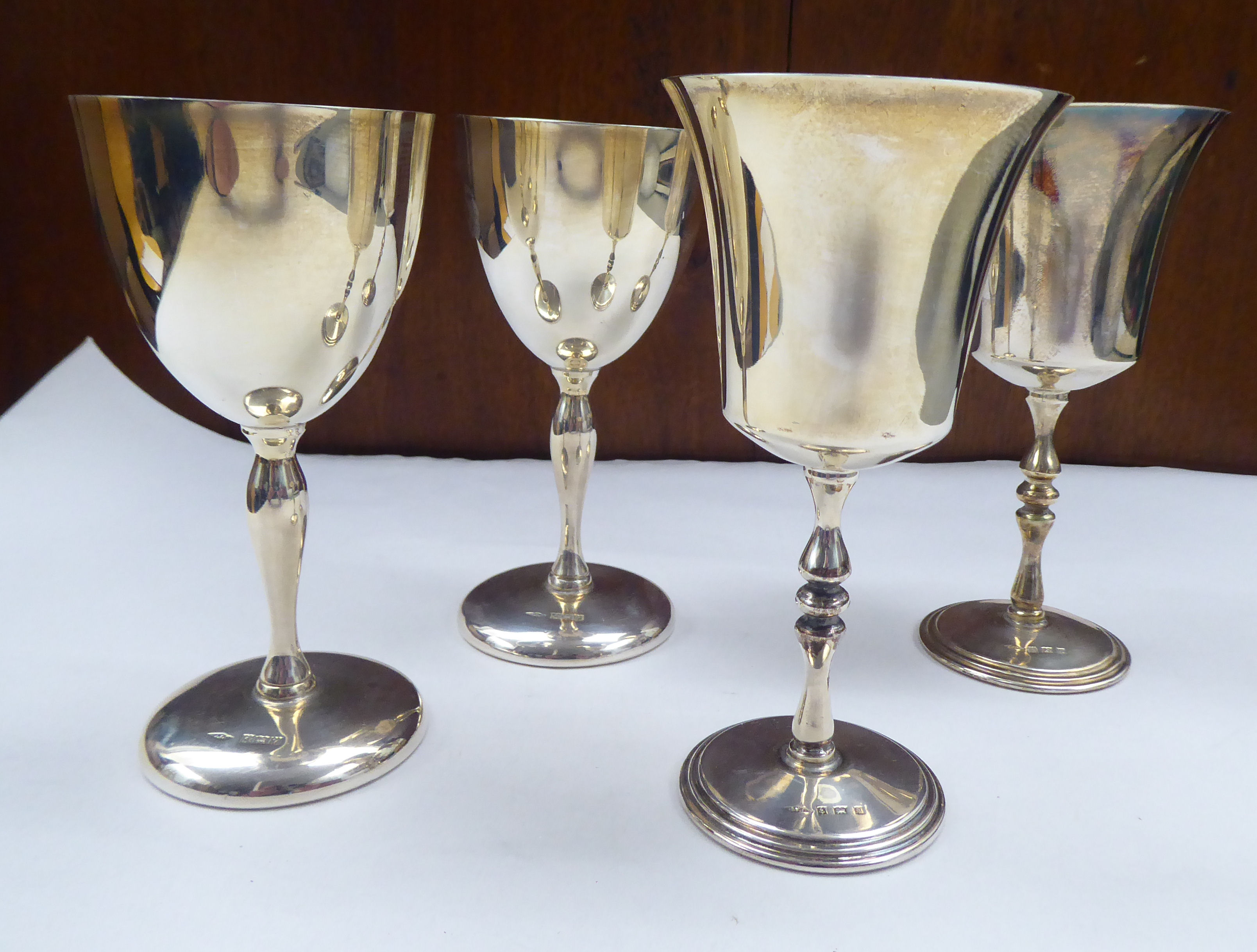 A pair of silver stemmed goblets with bell shape bowls; and a pair of similar with cup design bowls