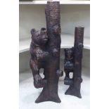 Two carved and stained Black Forest inspired candle stands, each featuring a brown bear  18"h  24"h