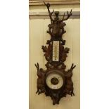 A late 19thC carved Black Forest hanging barometer, decorated with hare's and stag's heads  30"h