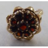 A 9ct gold floral design claw set ring with nine garnets