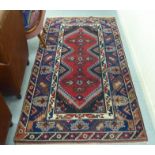 A North African rug, decorated with geometric shapes, on a multi-coloured ground  52" x 74"