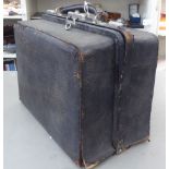 An early 20thC black Gladstone bag, the part fitted interior with glass receptacles