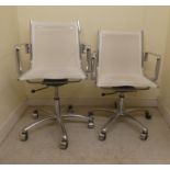 A pair of modern chromium framed Eames style swivel chairs, on castors