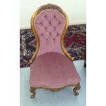 A late Victorian carved walnut nursing chair, part button upholstered in pink fabric, raised on