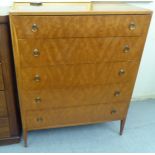 A mid 20thC teak finished five drawer dressing chest, raised on tapered legs  43"h  34"w