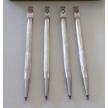 A set of four silver cased propelling pencils topped with playing cased symbols  3.5"L  cased