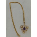 A Art Nouveau yellow metal inspired foliate design pendant, set with an amethyst, on a 9ct gold fine