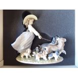 A Lladro Privilege porcelain figure group, a young girl walking a family of dogs  9"h  boxed