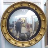 A 20thC Regency style convex mirror, in a gilt frame with ball ornament  22"dia