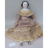 A French porcelain head and shoulders doll with black hair, rouged cheeks and closed mouth