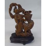 A Chinese Qing/Republic finely carved sandalwood figure, depicting a scholar alongside a kylim and a