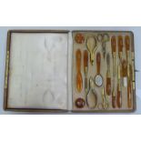 A 19thC French seventeen piece manicure set/etui with 18ct gold mounts, on amber coloured stems