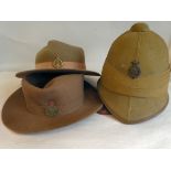 A British Army khaki cloth covered pith helmet with chinstrap and liner; and two brown/khaki