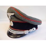 A German SS peak cap with red piping and emblem (Please Note: this lot is subject to the statement