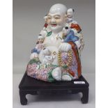 A mid 20thC Chinese porcelain figure, Buddha in typical seated pose with idle children, decorated in