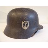 A World War II German SS steel helmet with one decal, chinstrap, liner and an indistinct inscription