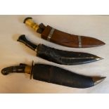 Two dissimilar kukris, each with a pair of skinning knives and 11"L blades and sheaths; and a