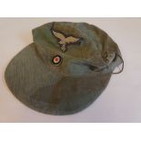 A German military camouflage ski cap with embroidered emblems  stamped 1945 (Please Note: this lot