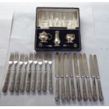 A set of nine loaded silver handled knives and forks; and a boxed set of three silver condiments