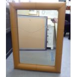 A modern mirror, in a tan coloured hide clad frame  40" x 30"