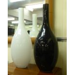 Two modern floorstanding glass vases, one white, the other red  24"h