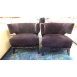 A pair of modern stud upholstered black fabric covered armchairs, raised on splayed forelegs