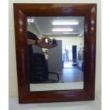 A 19thC mirror, set in a wide cushion moulded rosewood frame  26" x 21"