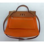 A Hermes orange fabric hand bag with brown leather trim