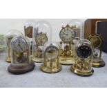Nine early/mid 20thC mainly lacquered brass anniversary style clocks, seven under domes  tallest