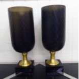 A pair of modern racing green coloured glass pedestal urns, on a plinth  18"h