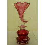 An early 20thC cranberry coloured glass scent bottle, the stopper surmounted by a cornucopia