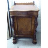 A late Victorian mahogany and walnut Davenport with a bank of four flank drawers, carved supports