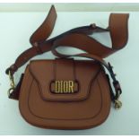 A Christian Dior tan coloured leather evening bag with an adjustable strap