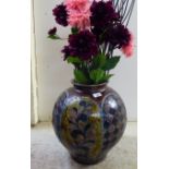 A 20thC stoneware vase of bulbous form  16"h containing a faux floral display