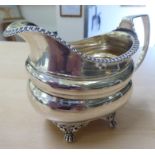 A George III silver cream jug of oval, ogee form, elevated on claw feet  London 1816