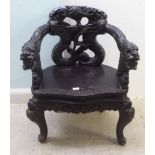 A late Victorian dark stained and profusely carved open arm chair, decorated in Sino-European